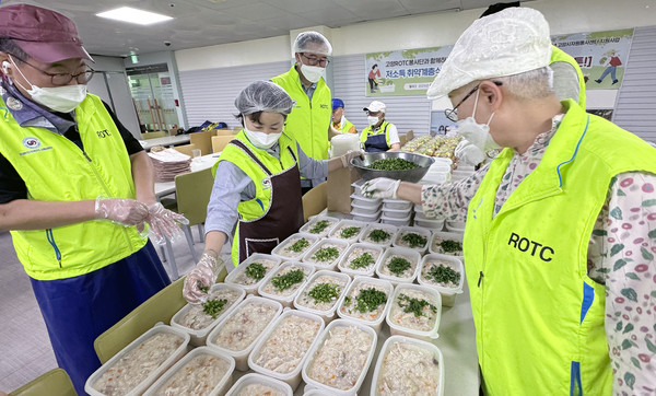 고양ROTC봉사단원들이 영양닭죽에 고명을 올리고 있다.