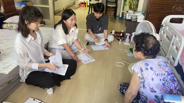 원흥종합사회복지관 직원들이 어르신과 이야기를 나누고 있다.