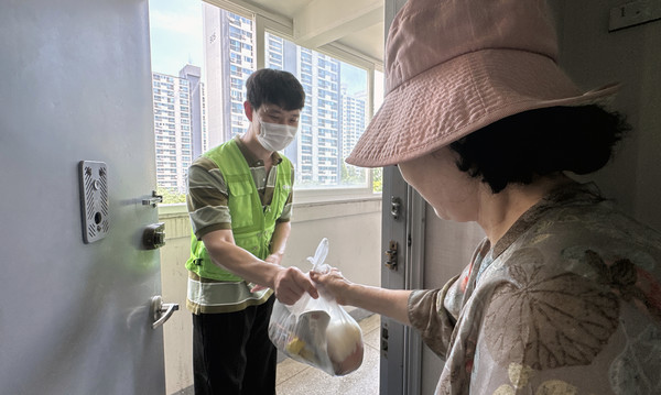 급식 봉사에 참여해 지역의 이웃에 삼계탕과 먹을거리 끄러미를 전달하는 박래신 씨.