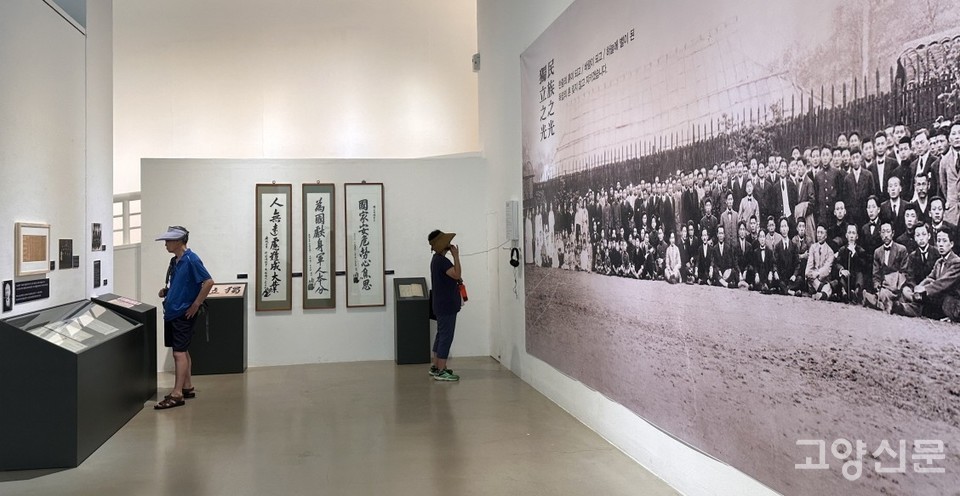 상해 독립운동가와 가족들을 찍은 대형 단체사진을 바라보고 있는 관람객.