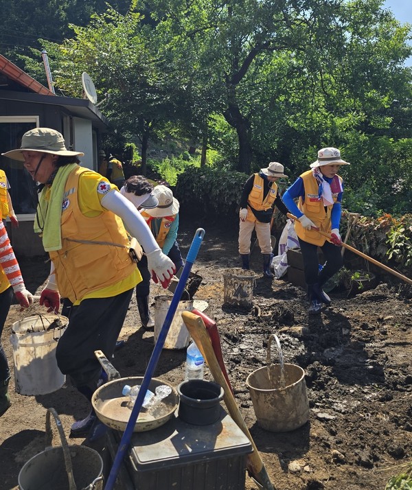 쏟아져내린 흙을 제거하며 땀흘리는 봉사원들. [사진제공=김상희]