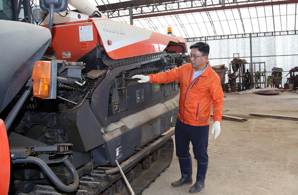 추석이 얼마 안 남았다. 추수할 때 쓸 콤바인을 둘러보며 기계점검을 하는 우 조합장.