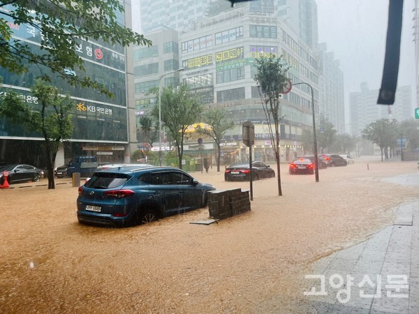 화정 롯데마트 사거리. 13일 낮 12시 현재 도로에 물이 차 차량 운행에 어려움을 겪고 있다. [사진=김진이 기자]