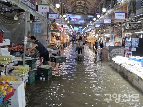 원당시장 안에 물이 차 상인들이 급하게 물건을 정리하고 있다. [사진=이병우 기자]