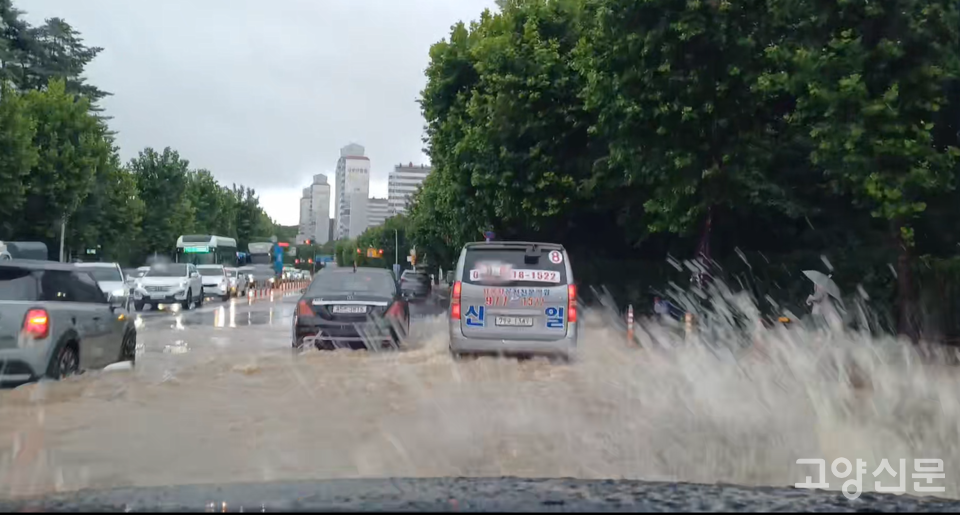 침수 위험을 무릅쓰고 저지대 도로를 통과하고 있는 차량들. 