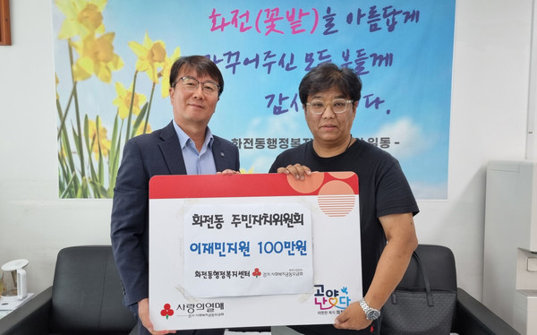  화전동 주민자치회가 후원금을 전달하고 있다.