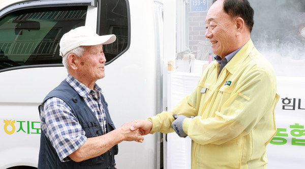 조합원을 만나 반갑게 인사하는 장순복지도농협 조합장(오른쪽)