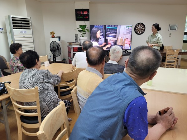  어르신들이 디지털 기기 사용에 관한 영상을 집중해 보고 있다.