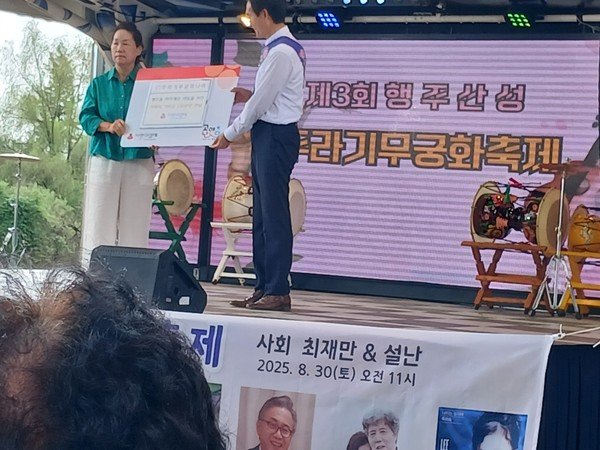  박무궁 목사(오른쪽)이 소년소녀 가정돕기 기부금을 전달하고 있다.