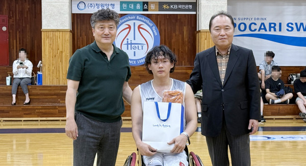 고양홀트와 무궁화전자 경기에서 고양홀트팀 김홍수 선수(가운데)가 페어플레이상을 받았다. 사진은 왼쪽부터 김재현 고양홀트휠체어농구단장, 김홍수 선수, 안병태 한국휠체어농구연맹 총재.