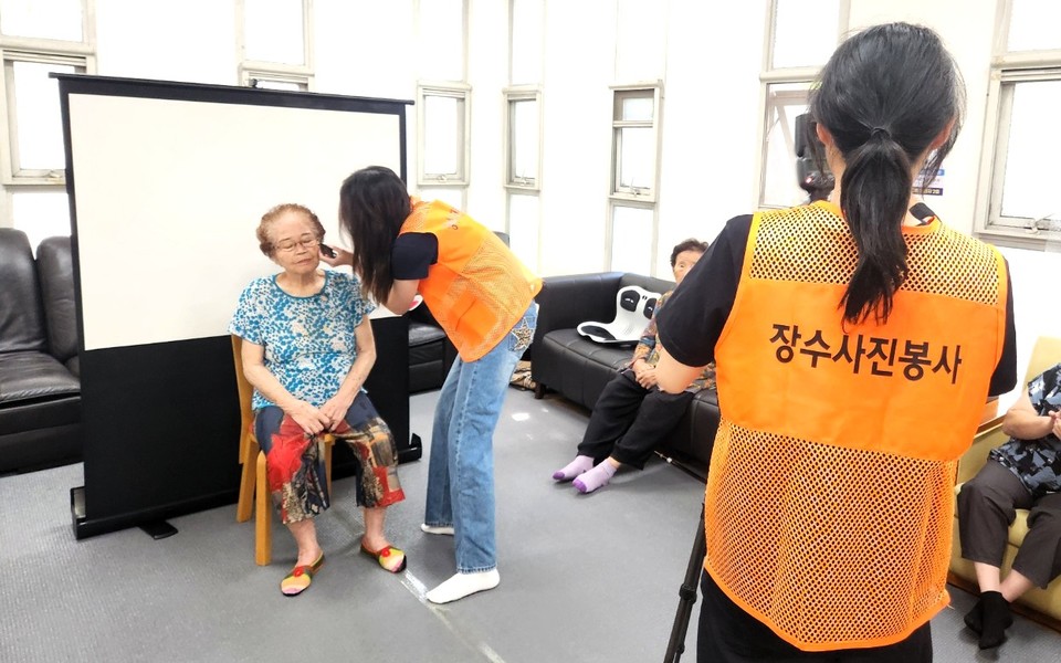 지난달 일산동구 한 경로당에서 사진기를 다루는 동생 박도연양과 어르신 메이크업과 헤어스타일링을 돕는 언니 박도영양. 쌍둥이 자매는 "우리를 필요로 하는 더 많은 어르신들을 위해 봉사를 이어갈 계획"이라고 말했다.