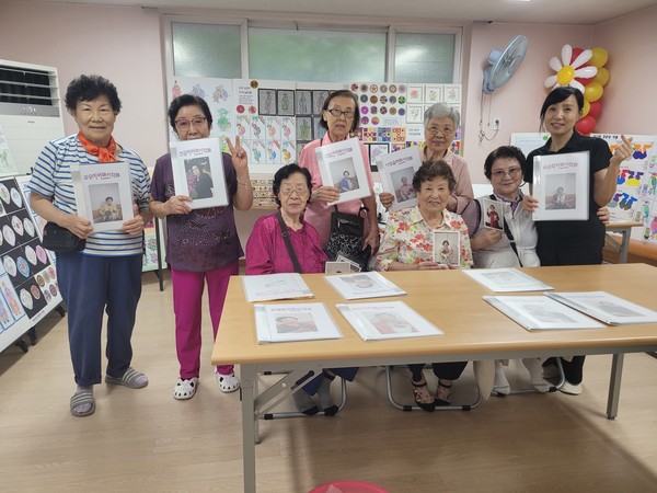 전시회 참가 어르신들이 각자 그린 그림을 소개하고 있다.