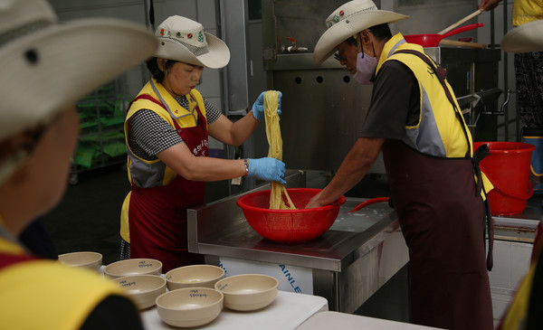 면을 바로 뽑아 짜장면을 담는 봉사단원들.