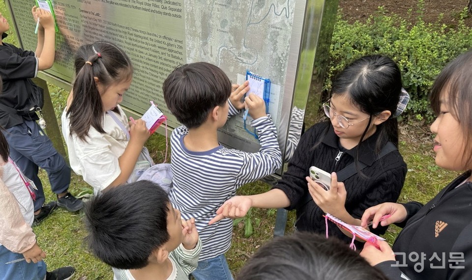 양주시 삼하리 해피밸리 전투 기념지에서 설명판의 글을 꼼꼼히 옮겨 적고 있는 탐방대원들.