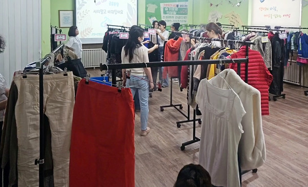 21% 의류교환파티에서 옷을 고르는 시민들.