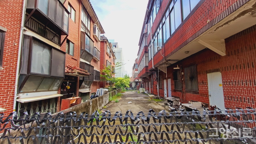 입주자들이 떠나가고 검정 필름이 둘러쳐진 연립주택.  