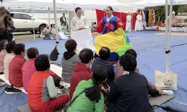시민들에게 덕담하며 전통굿을 통해 다양한 이야기를 전하는 모습.