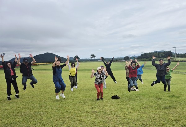 보호자들이 단체 점프를 하면서 제주도 힐링여행을 즐기고 있다.