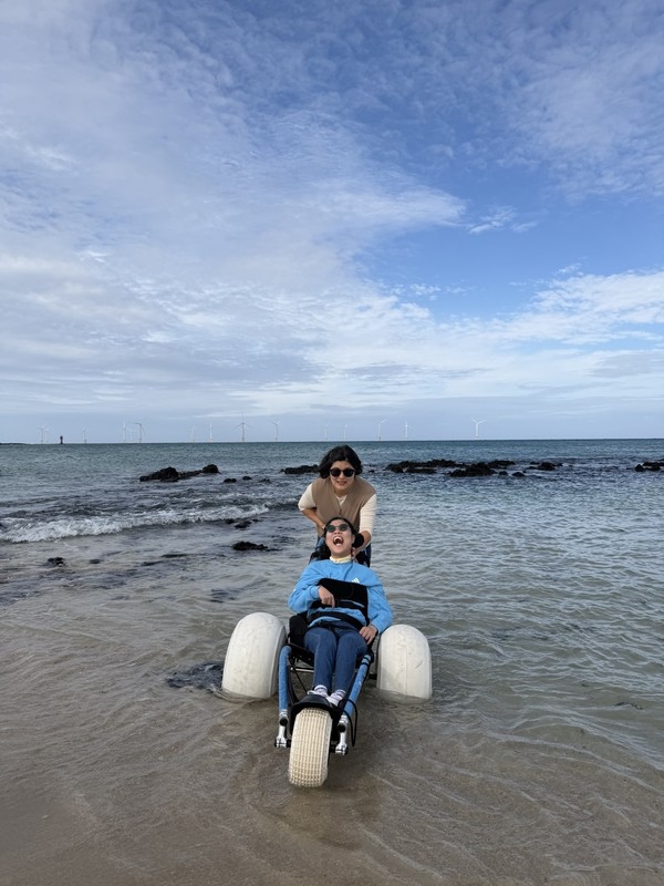  곽지해수욕장에서 해변용 휠체어를 즐기는 한 가족
