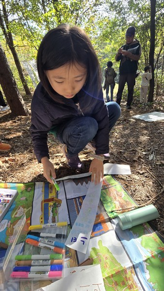 강해인(장성초 2) 양이 산황산을 지키자는 내용의 글을 종이에 쓰고 있다. 