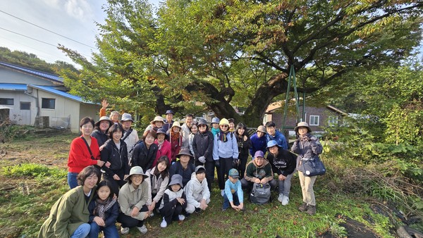 마을숲 탐사대원들이 지난달 25일 산황산 들머리 용뿔 느티나무 앞에서 기념촬영을 하고 있다.