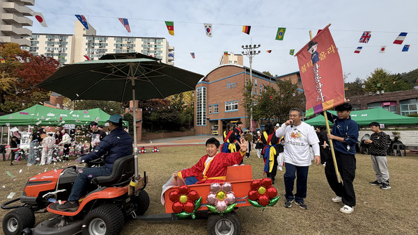  우승한 선수가 꽃차를 타고 운동장을 돌며 축하를 받고 있다.