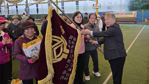 우승을 한 중산D팀에 우승기를 전달하는 임은택 이사장(맨 오른쪽)