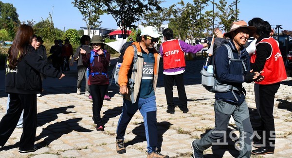 10㎞ 완주지점에 도착한 참가자들을 신한라이프 자원봉사자들이 축하의 말과 환호로 맞이하고 있다. 