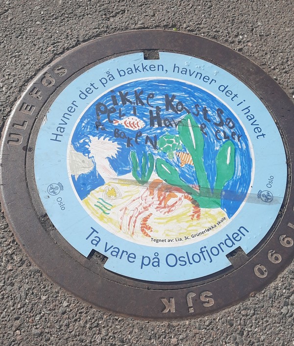 "땅에 떨어지면 바다로 가요 ; 오슬로 피오르드를 지켜주세요" 맨홀뚜껑 캠페인 사진 - 학생들이 그린 환경보호 그림을 선정 제작한 환경보호 문구를 맨홀뚜껑 위에 부착한 모습. [이철규 북유럽특파원]