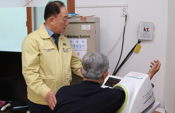 장순복 조합장이 기증한 혈압계로 한 어르신과 혈압을 측정하고 있다.