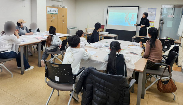  가족 체험 활동으로 부모님과 함께 하는 베어브릭 꾸미기 활동이 진행되고 있다.