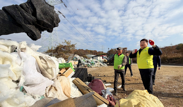 홍성규 조합장이 농민단체 조합원과  폐농자재를 선별해 이동시키고 있다.
