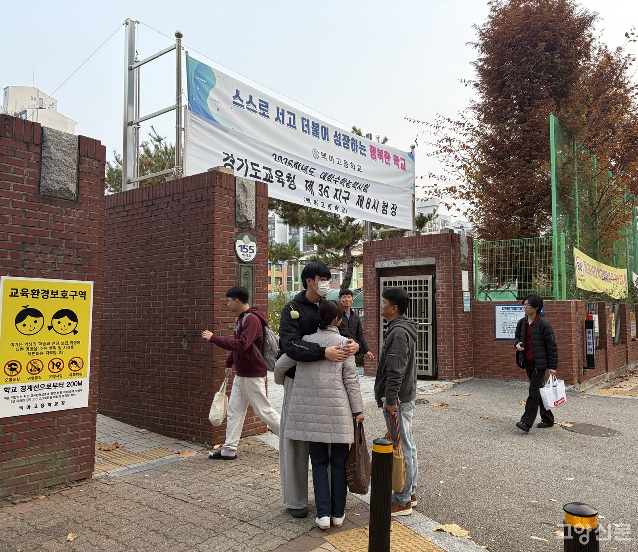 수능시험일인 13일 일산 백마고 정문 앞. 수험생이 응원 온 가족을 꼭 안고 있다.