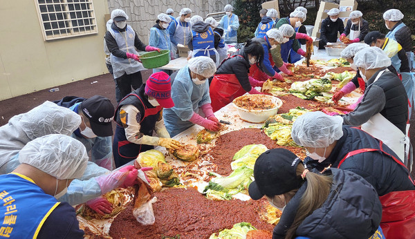 고양시장애인복지관 김장나눔에 함께 참여한 로타리클럽 회원들이 김장을 담고 있다.