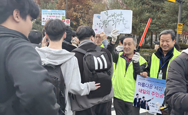  학생들에게 응원을 하는 원신동청소년지도위원협의회 위원들.