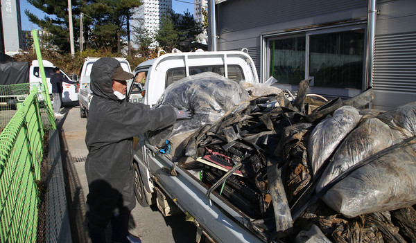 이석일 조합장이 조합원이 싣고 온 폐비닐을 확인하고 분리 위치를 안내하고 있다.  