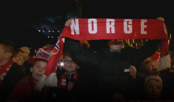 노르웨이를 상징하는 국기와 노르게(Norge) 마크를 든 어린이가 월드컵 대표팀의 본선 진출을 환영하고 있다. 노르웨이 공영방송 NRK 보도화면 캡처. [이철규 북유럽특파원]