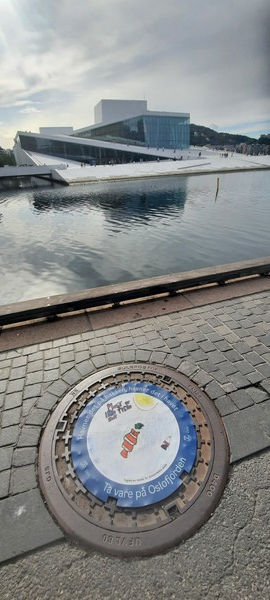 노르웨이 오슬로 오페라하우스 앞 피오르드 환경보호 멘홀뚜껑 - 학생들이 환경보호를 주제로 그린 미세플라스틱의 위험성 경고 그림을 멘홀뚜껑에 붙여놓았다. [이철규 북유럽특파원]