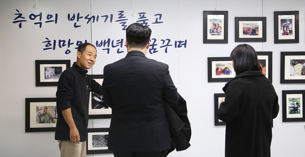 사진전에서 허남석 부장 교사가 학부모들에게 사진을 하나하나 설명하고 있다. 과거와 현재를 말했다.