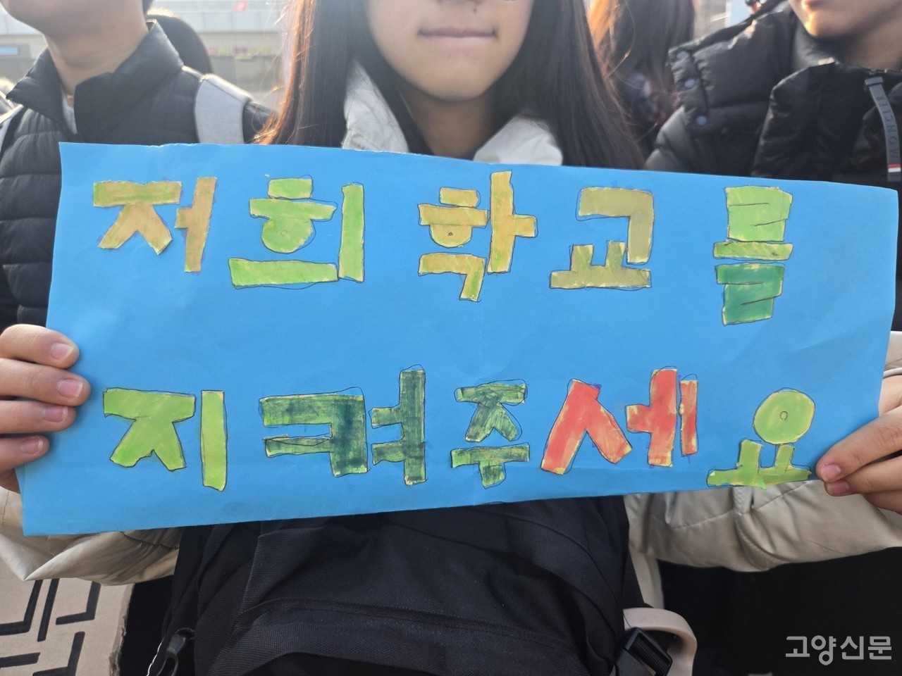 매서운 추위 속에서도 아이들은 '저희 학교를 지켜주세요'라고 적은 피켓을 들고 거리로 나섰다.