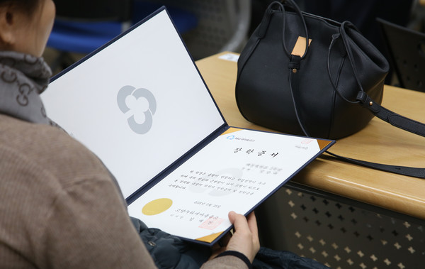 전달된 장학증서를 바라보는 한 학생.