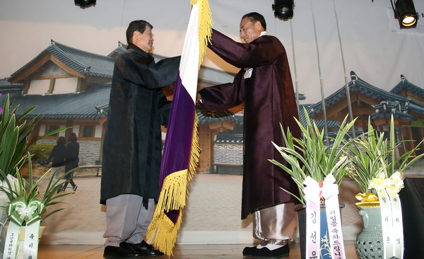 김용규 이임원장(왼쪽)이 이봉운 신임원장에게 고양문화기를 전달하고 있다.