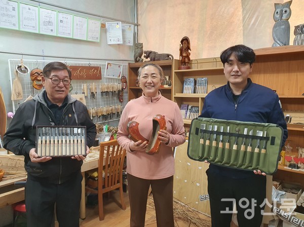 (왼쪽부터)김상수 대표는 56년 내공 담긴 조각도를, 아내 박진희 작가는 15년 열정 담긴 나막신을, 아들 김도현씨는 조각도를 들고 포즈를 취했다.