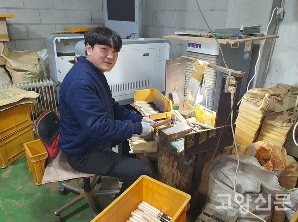 김도현씨가 조각날에 자루를 끼워 넣어 균형을 맞추고 있다.