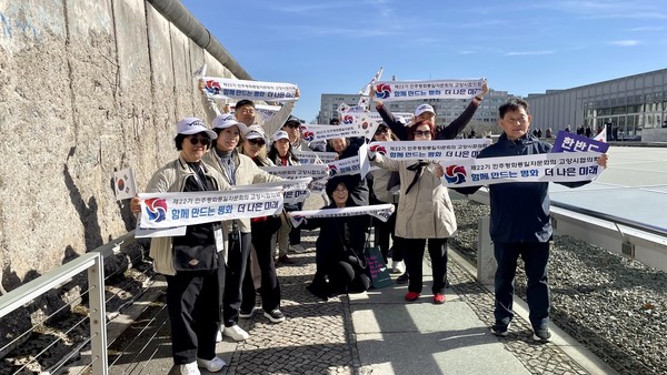 민주평통 고양시 협의회 자문위원들이 북유럽 협의회와의 협력 협약식후 베를린장벽 인근에서 팻말을 들고 단체 사진을 찍고있다. [민주평통 북유럽협의회 제공]