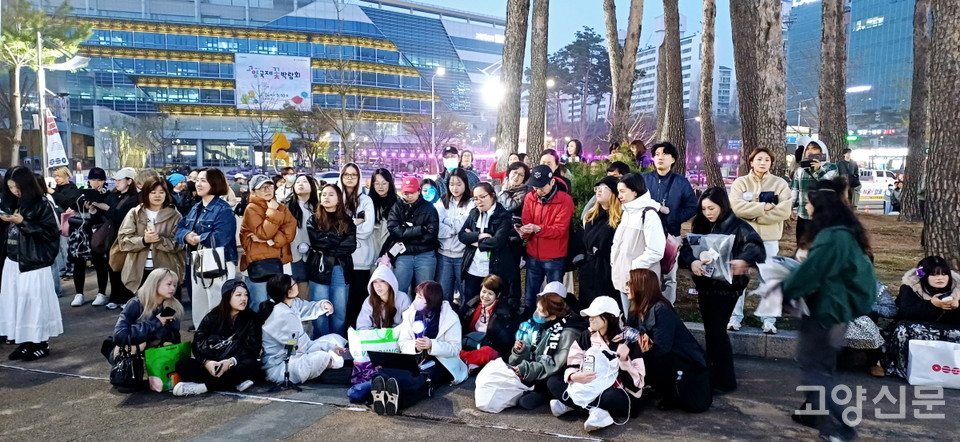 노트북 화면으로 중계되는 코서트장 영상을 함께 보며 환호하고 있는 아미들.  