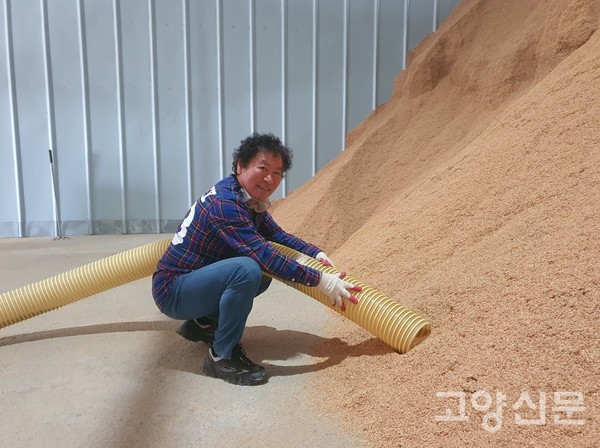 최길복 회장이 미곡처리장에서 수거해온 왕겨를 진공청소기 원리로 흡입하는 과정을 보여주고 있다.