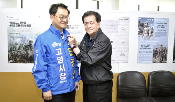 민경선 후보에게 호국보훈 배지를 달아주는 대한민국전몰군경유족회 고양시지회 추재호 지회장(오른쪽).
