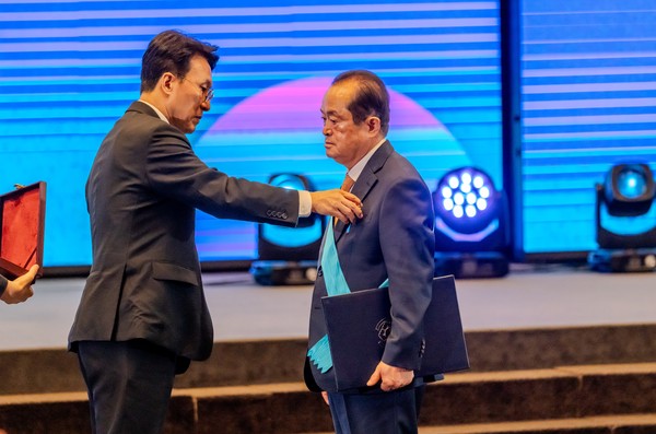 19일 서울 여의도 중소기업중앙회에서 열린 ‘제37회 대한민국 중소기업인 대회’에서 고양시 기업인 최초로 금탑산업훈장을 안은 이능구 칠갑농산 대표(오른쪽)가 김민석 국무총리(왼쪽)로부터 훈장을 받고 있다.