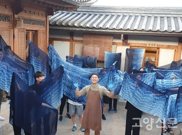 홍루까 대표의 아들 홍성하씨가 수강생들과 쪽으로 체험한 천연염색 천을 보여주고 있다.